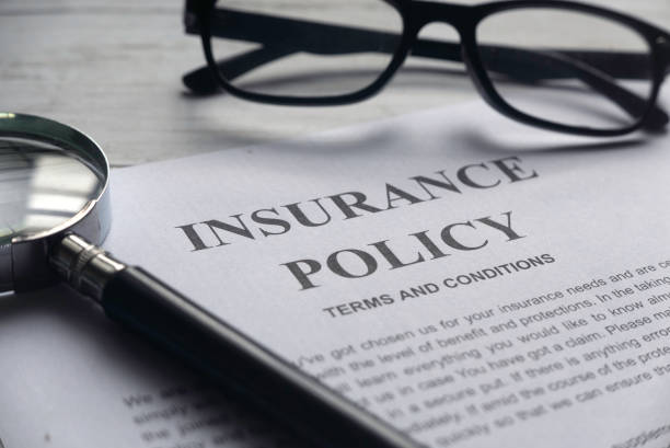 Insurance policy terms and conditions with a magnifying glass and glasses