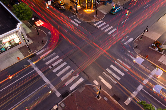 Aerial view of a city intersection at dusk with traffic light trails