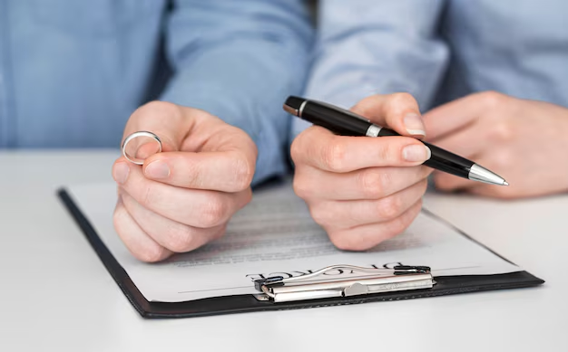 Worried couple holding a baby while reviewing bills at a laptop