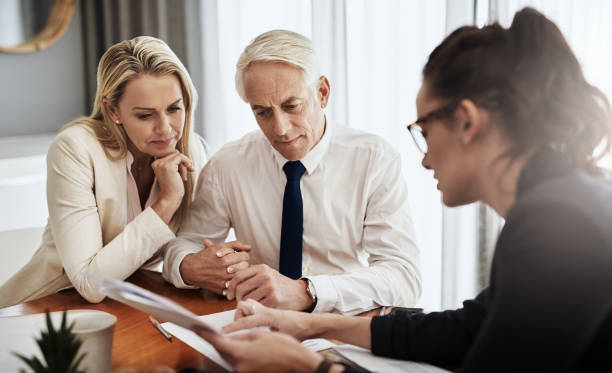 Older couple reviewing documents with an advisor across a table