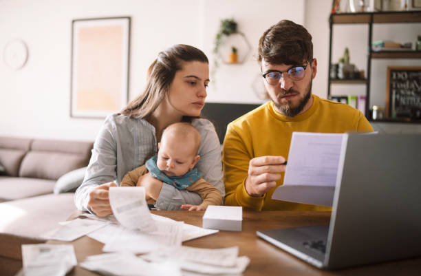 Middle-aged couple reviewing documents at a table with a tablet and papers