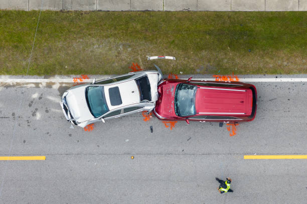Aerial view of two cars collided on a road with evidence markers