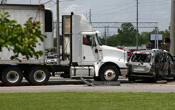 Semi truck stopped at an intersection after colliding with a crushed SUV