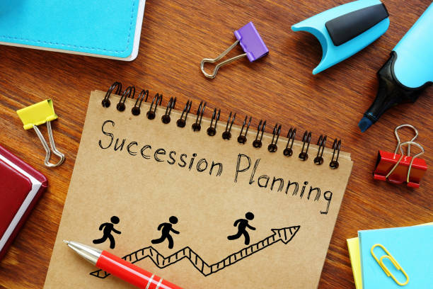 Succession Planning written on a notebook page with stick figures running up an arrow